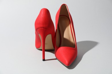 Photo of Red high heeled shoes on light background