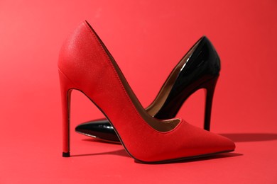 Photo of Beautiful high heeled shoes on crimson background