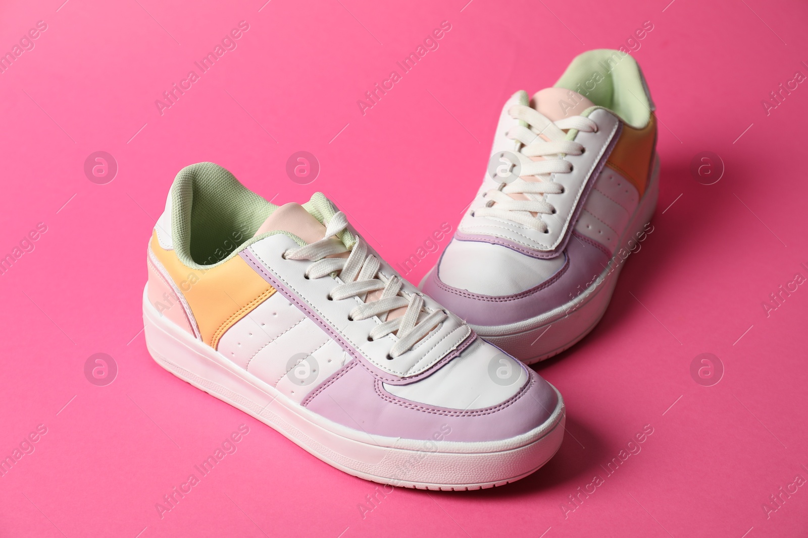 Photo of Stylish sneakers on pink background. Sportive shoes