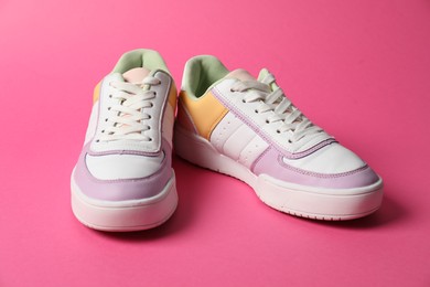 Photo of Stylish sneakers on pink background. Sportive shoes