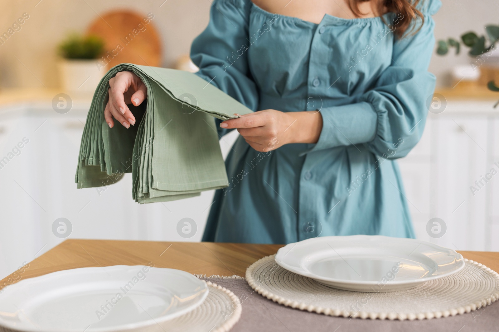 Photo of Woman setting table for dinner at home, closeup