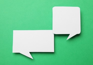 Photo of Blank speech bubbles on green background, top view. Space for text