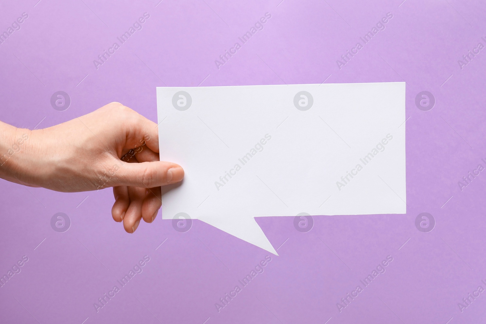 Photo of Woman holding blank speech bubble on lilac background, closeup. Space for text