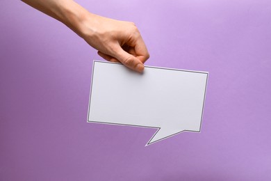 Photo of Woman holding blank speech bubble on lilac background, closeup. Space for text