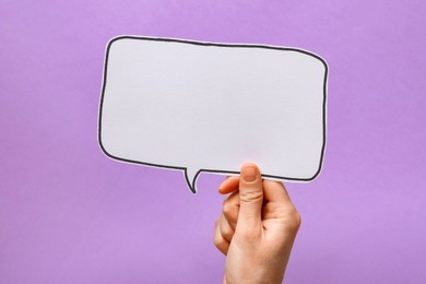 Photo of Woman holding blank speech bubble on lilac background, closeup. Space for text