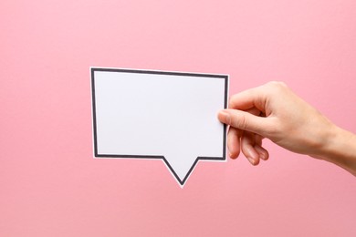 Photo of Woman holding blank speech bubble on light pink background, closeup. Space for text