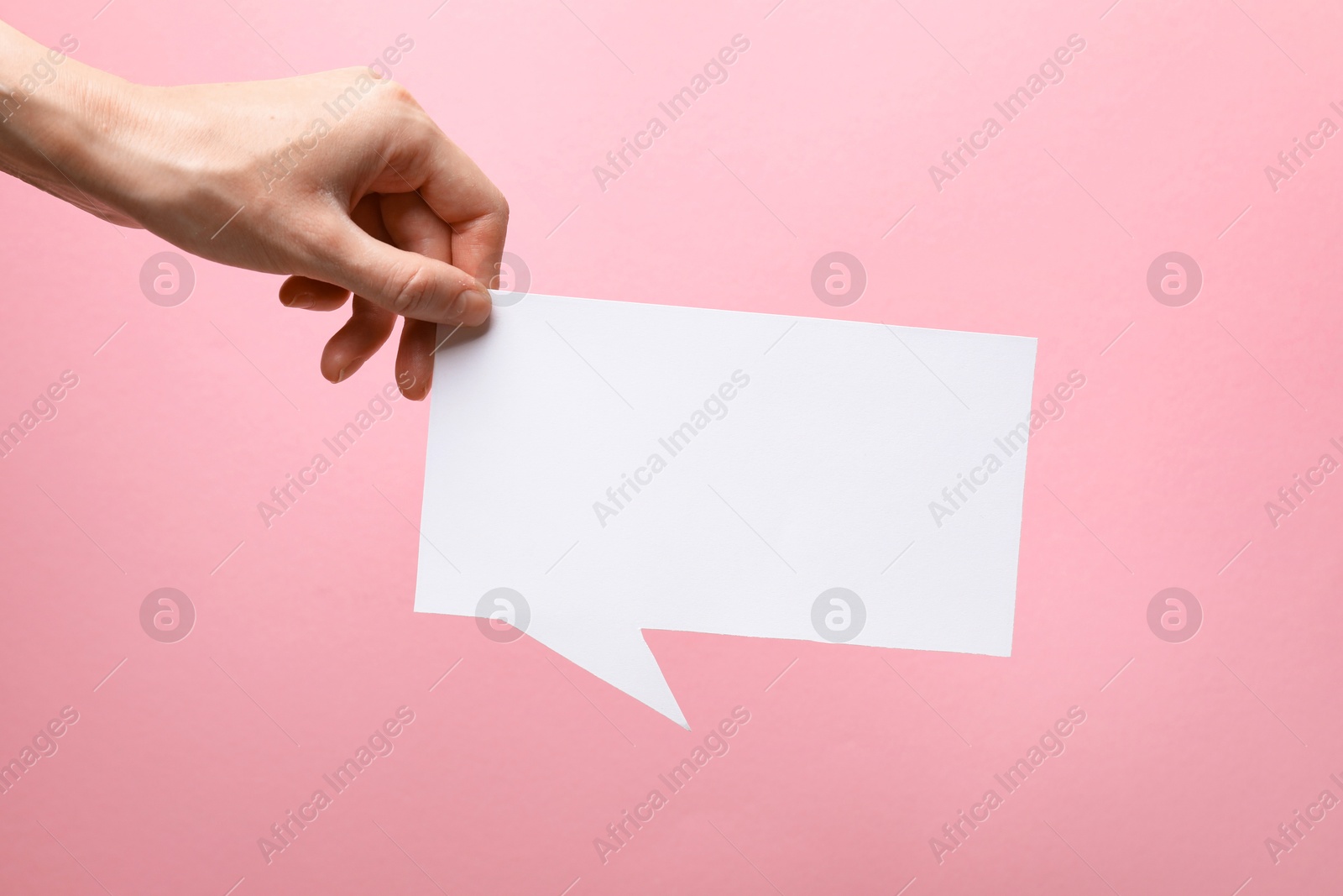 Photo of Woman holding blank speech bubble on light pink background, closeup. Space for text