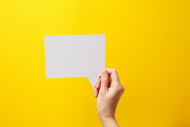 Photo of Woman holding blank speech bubble on yellow background, closeup. Space for text