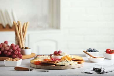 Photo of Different types of cut cheese and other snacks on light textured table indoors, space for text