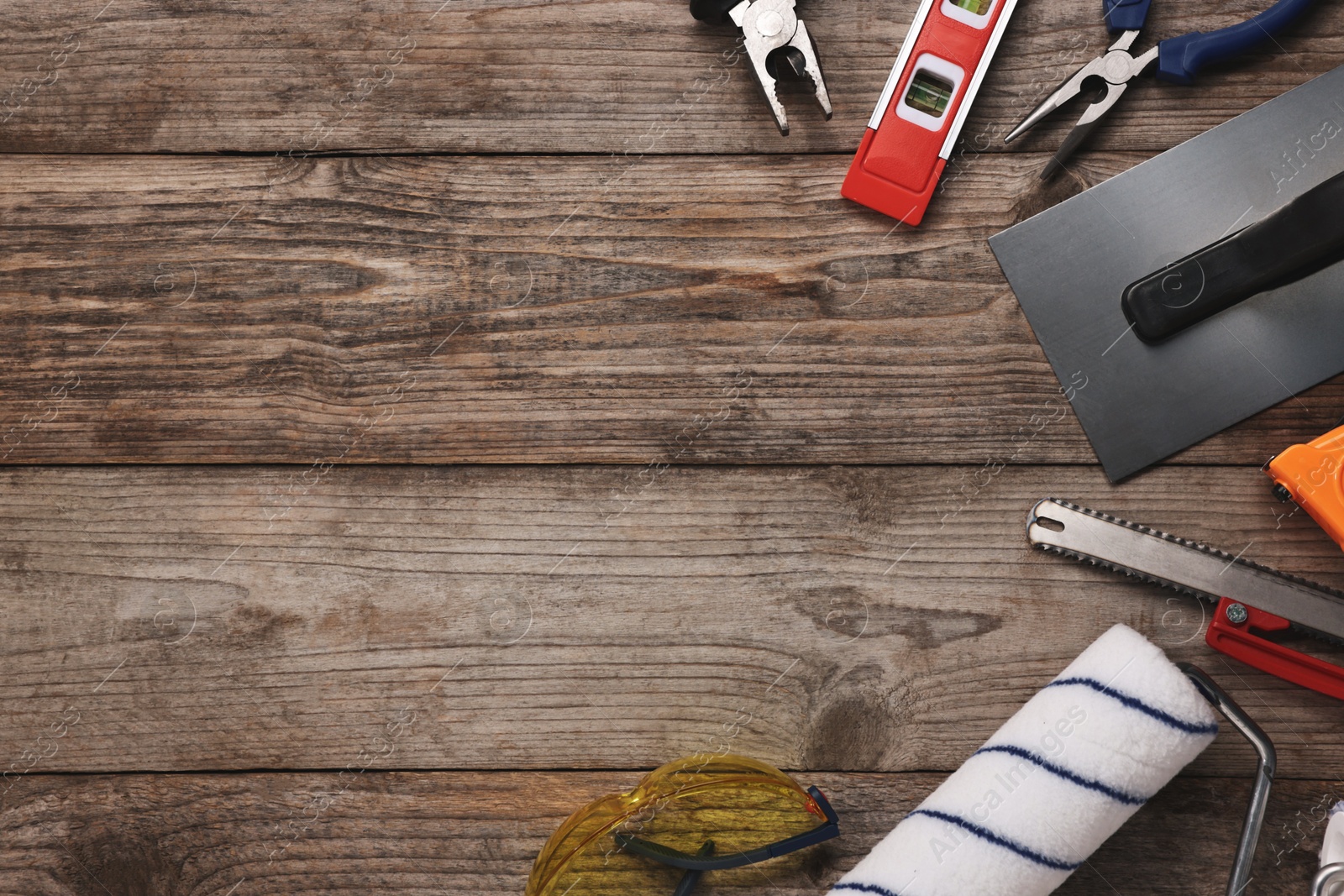 Photo of Different construction materials and tools on wooden table, flat lay. Space for text