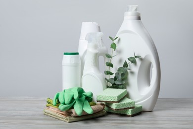 Photo of Eco-friendly cleaning products, supplies and eucalyptus branches on wooden table