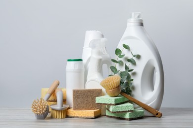 Photo of Eco-friendly cleaning products, supplies and eucalyptus branches on wooden table