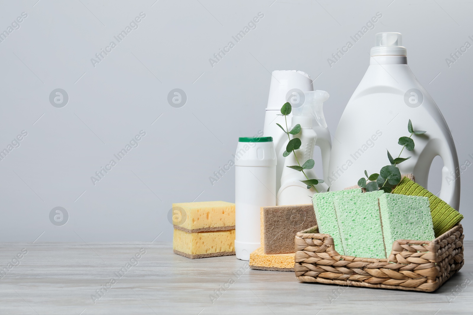 Photo of Eco-friendly cleaning products, supplies and eucalyptus branches on wooden table, space for text