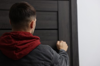 Photo of Man knocking on door of his friends apartment