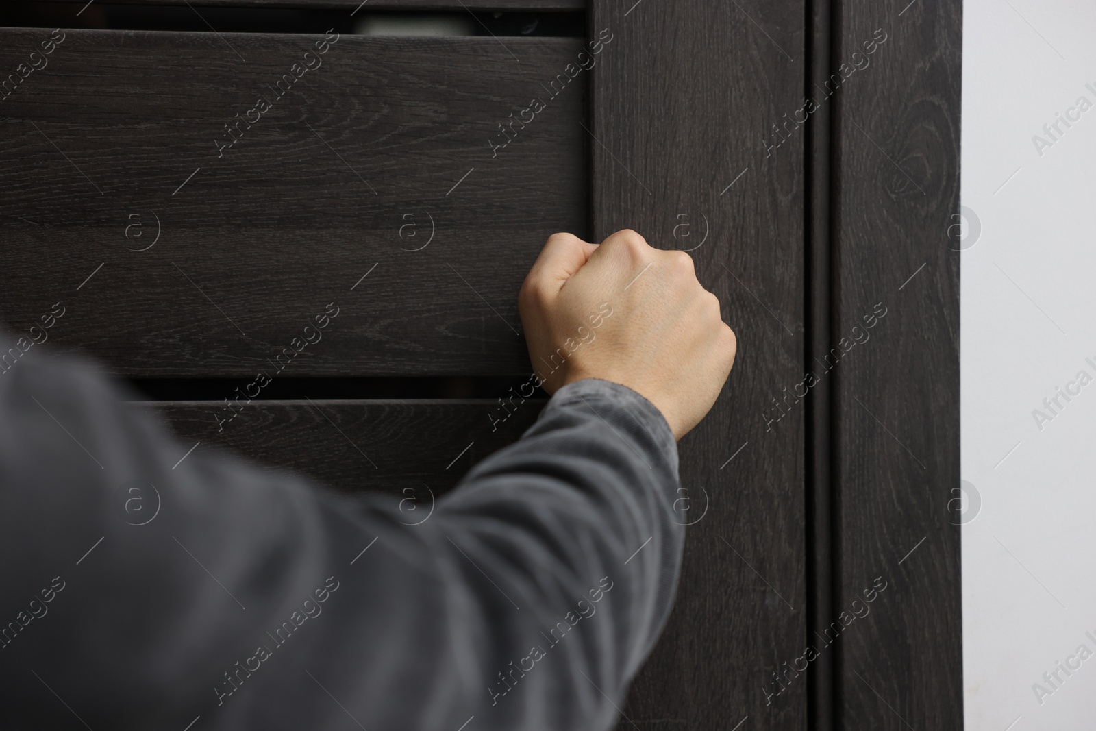 Photo of Man knocking on door of his friends apartment, closeup