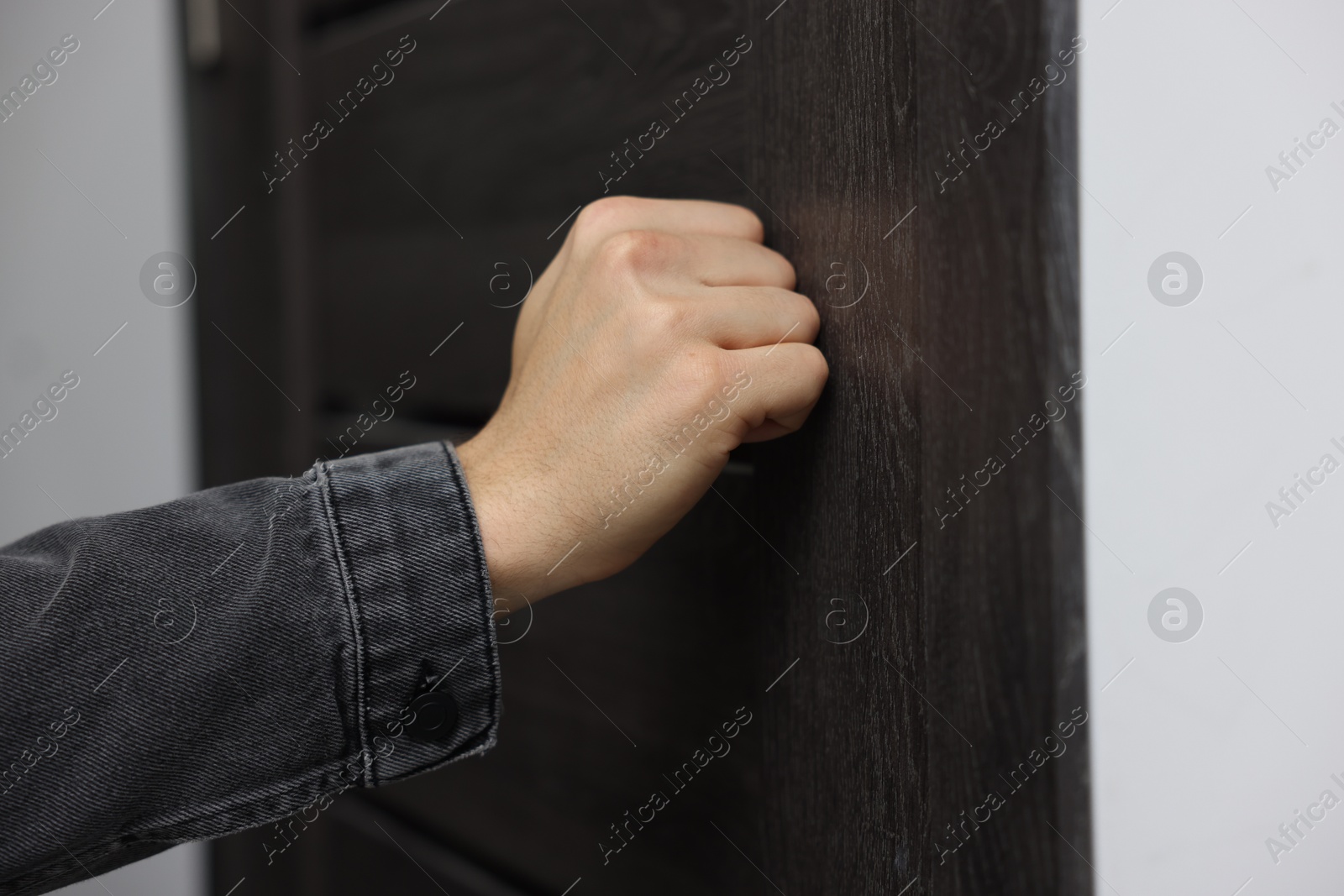 Photo of Man knocking on door of his friends apartment, closeup