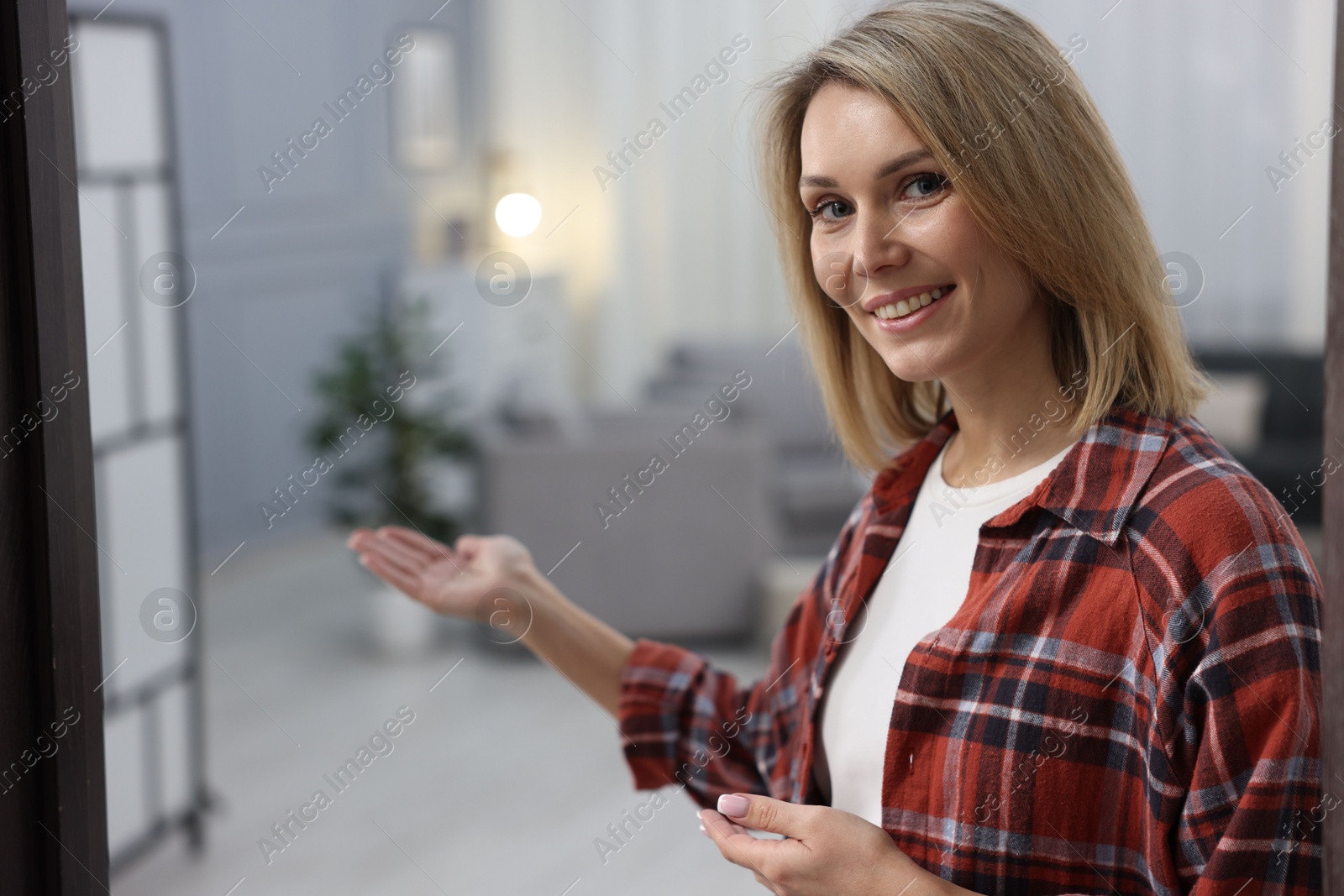 Photo of Happy woman welcoming friend to her house