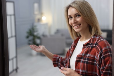 Photo of Happy woman welcoming friend to her house