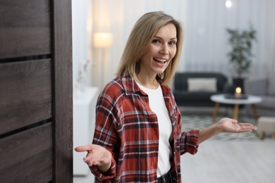 Photo of Happy woman welcoming friend to her house