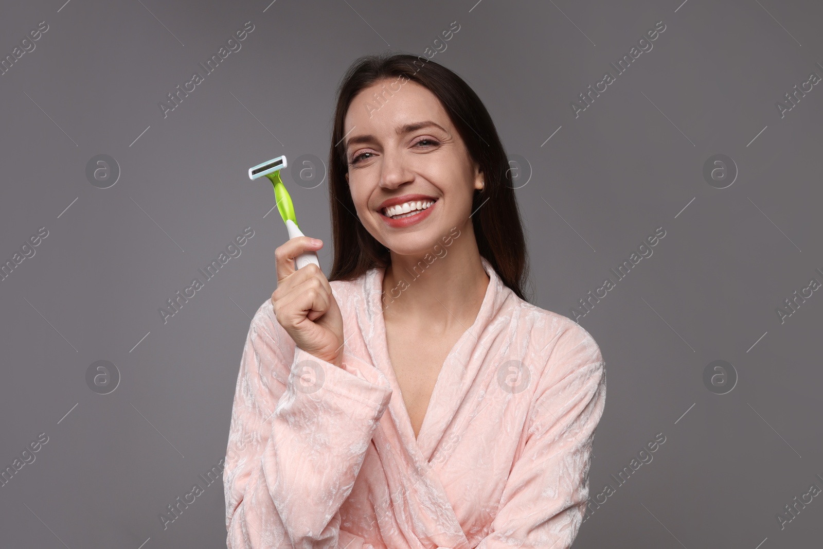 Photo of Happy woman with razor on grey background. Hair removal tool