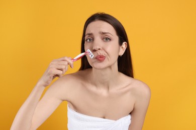 Photo of Beautiful woman shaving her mustache with razor on orange background