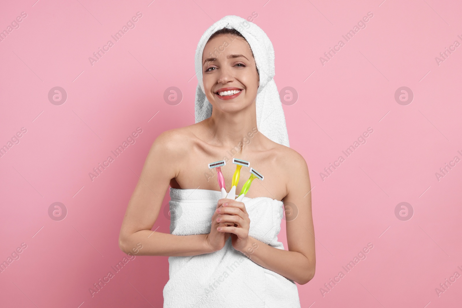 Photo of Happy woman with different razors on pink background. Hair removal tool