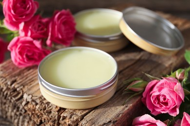 Photo of Natural solid perfume and pink roses on wood, closeup