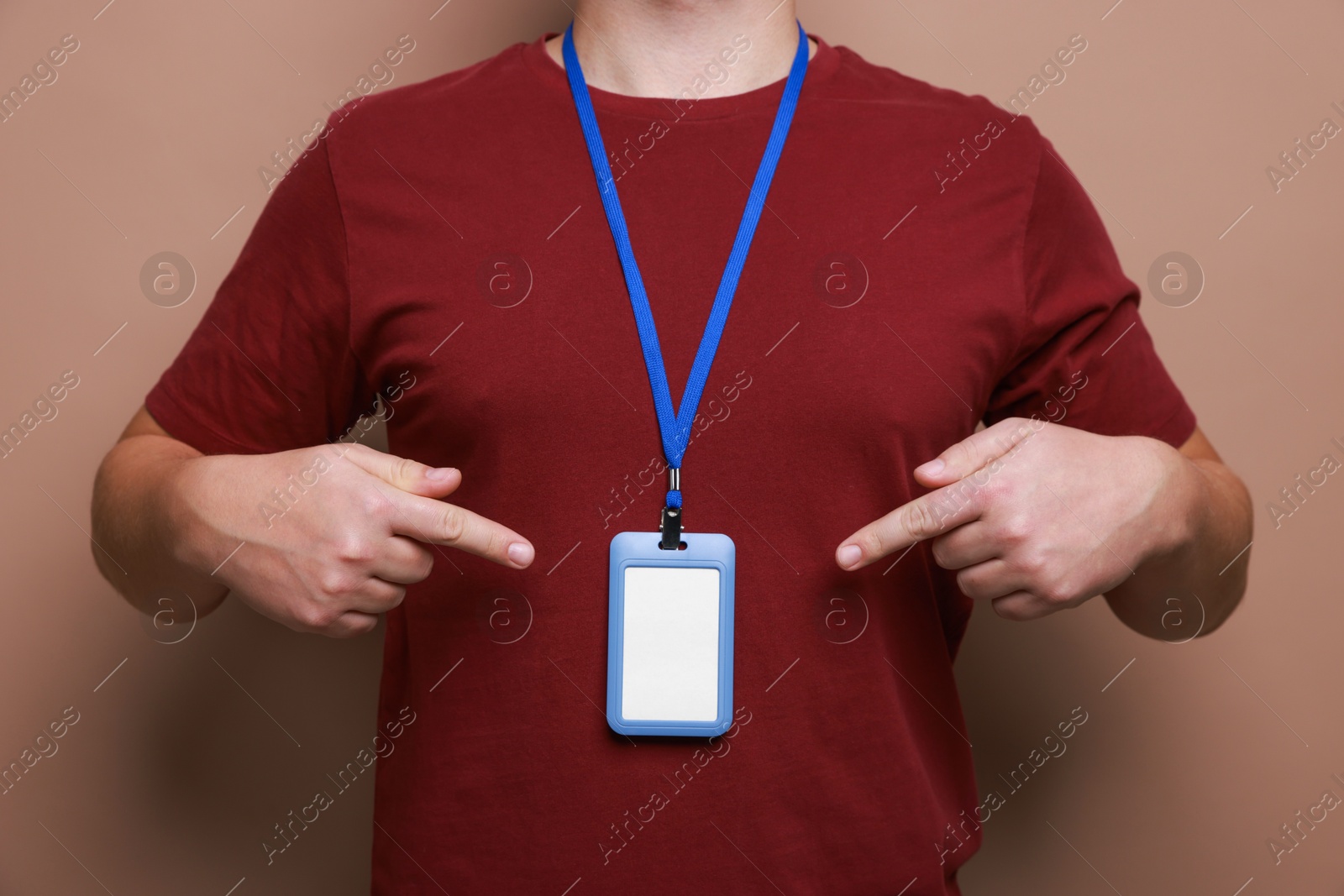 Photo of Man with blank badge on brown background, closeup