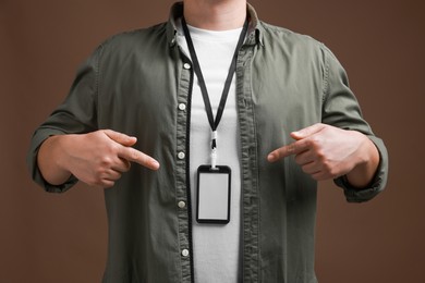 Photo of Man with blank badge on brown background, closeup