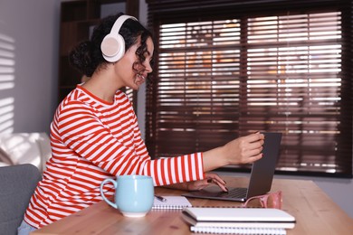 Photo of Beautiful woman working on laptop at desk in home office