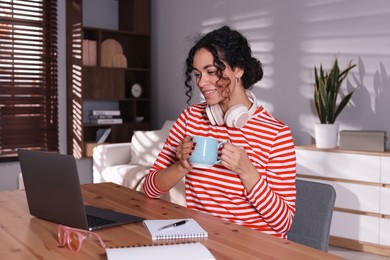 Photo of Beautiful woman working on laptop at desk in home office