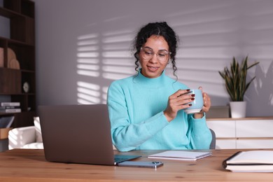 Photo of Beautiful woman working on laptop at desk in home office