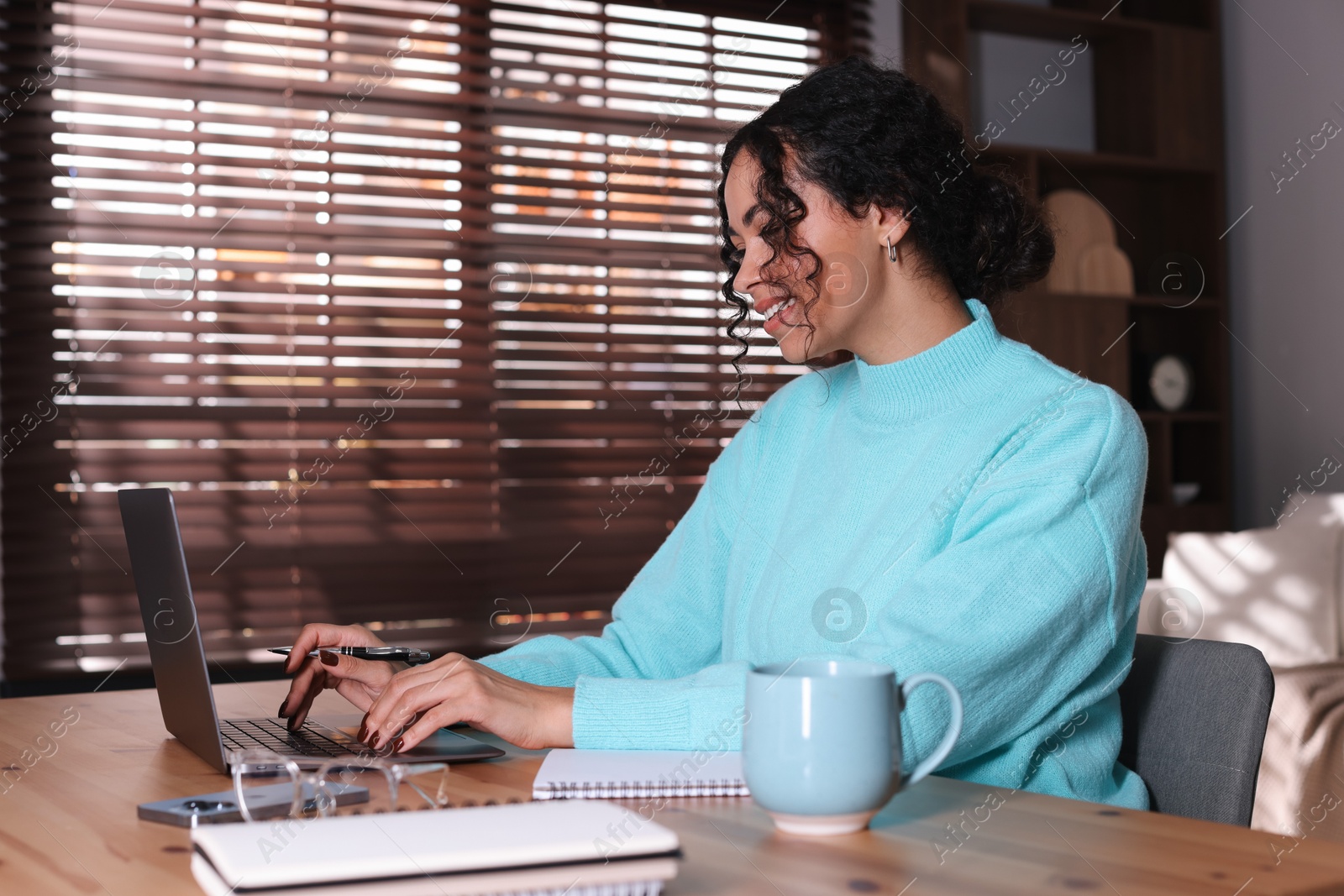 Photo of Beautiful woman working on laptop at desk in home office