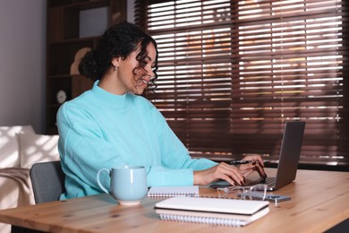 Photo of Beautiful woman working on laptop at desk in home office