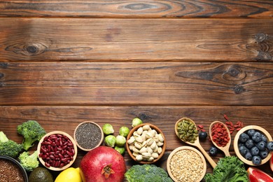 Photo of Different superfood products on wooden table, flat lay. Space for text