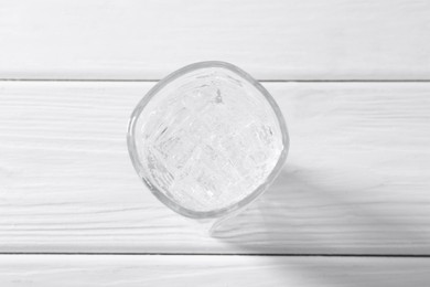 Photo of Refreshing soda water with ice cubes in glass on white wooden table, top view