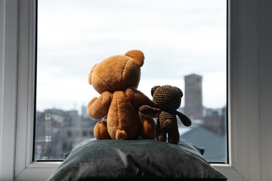 Photo of Two cute teddy bears near window indoors, back view