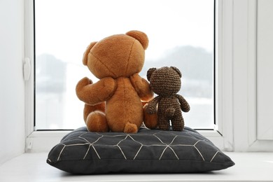 Photo of Two cute teddy bears near window indoors, back view