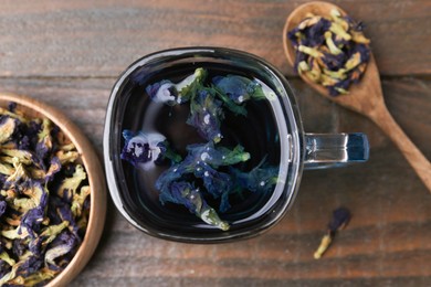 Photo of Delicious butterfly pea flower tea on wooden table, flat lay