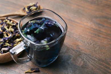 Photo of Delicious butterfly pea flower tea on wooden table, closeup. Space for text