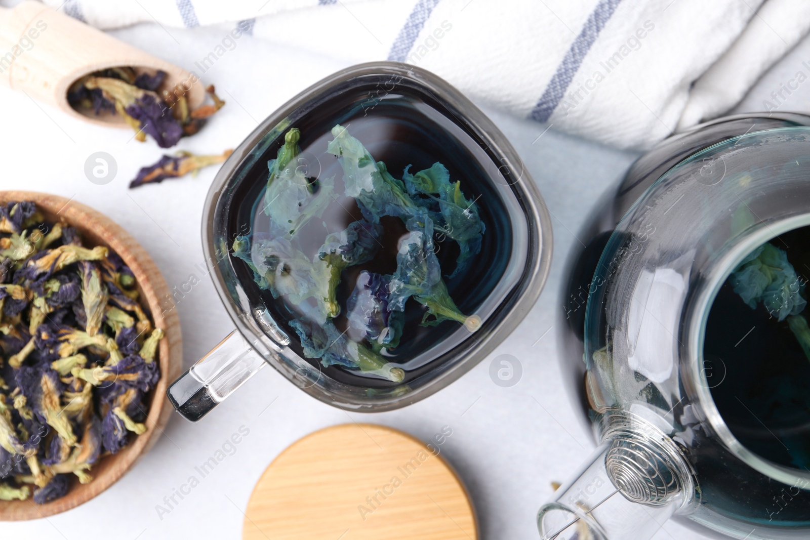 Delicious butterfly pea flower tea on white table, flat lay Photo of Delicious butterfly pea flower tea on white table, flat lay