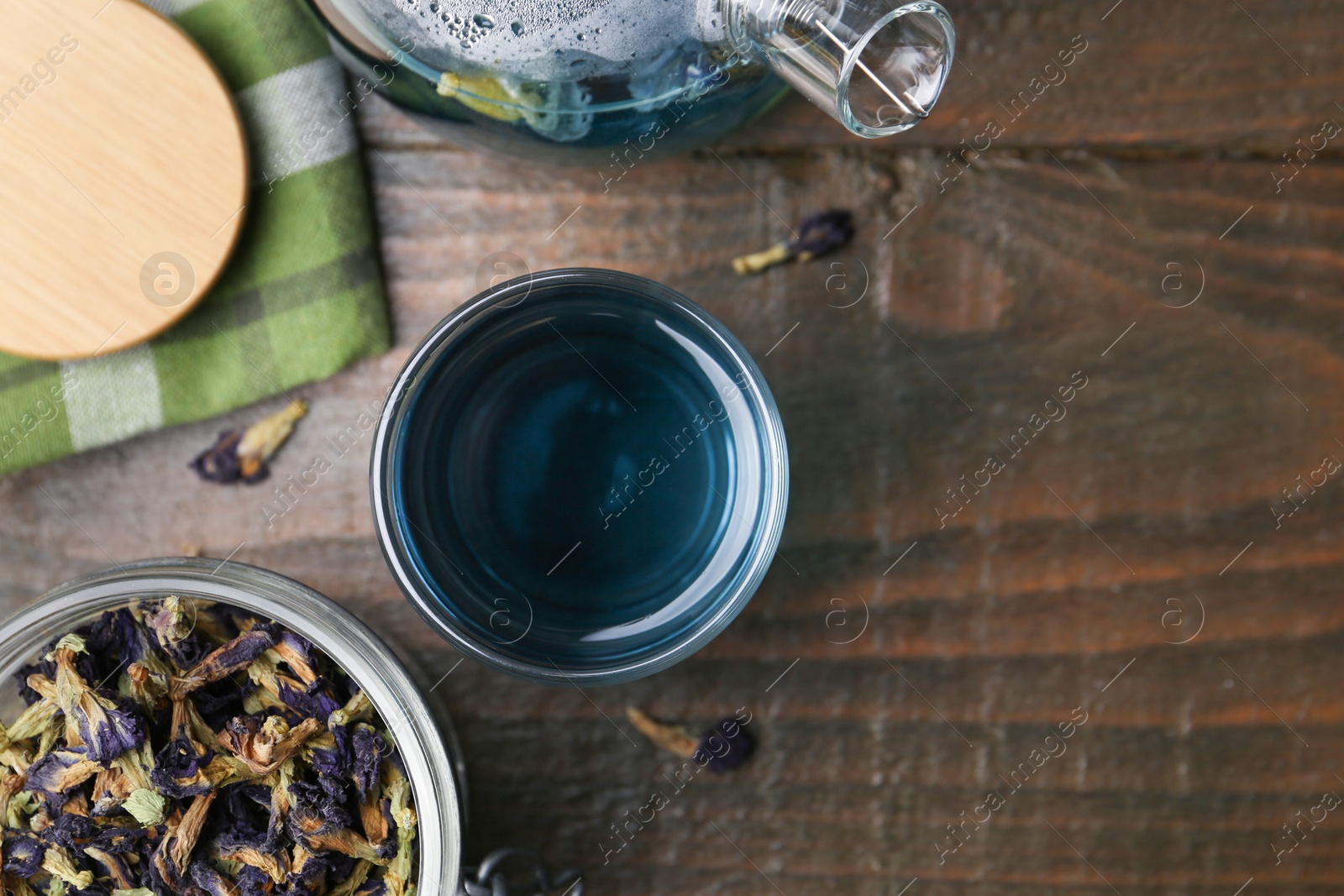 Photo of Delicious butterfly pea flower tea on wooden table, flat lay. Space for text