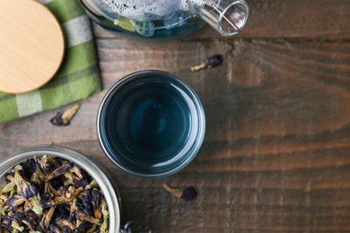 Delicious butterfly pea flower tea on wooden table, flat lay. Space for text