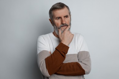 Photo of Portrait of mature man on light grey background