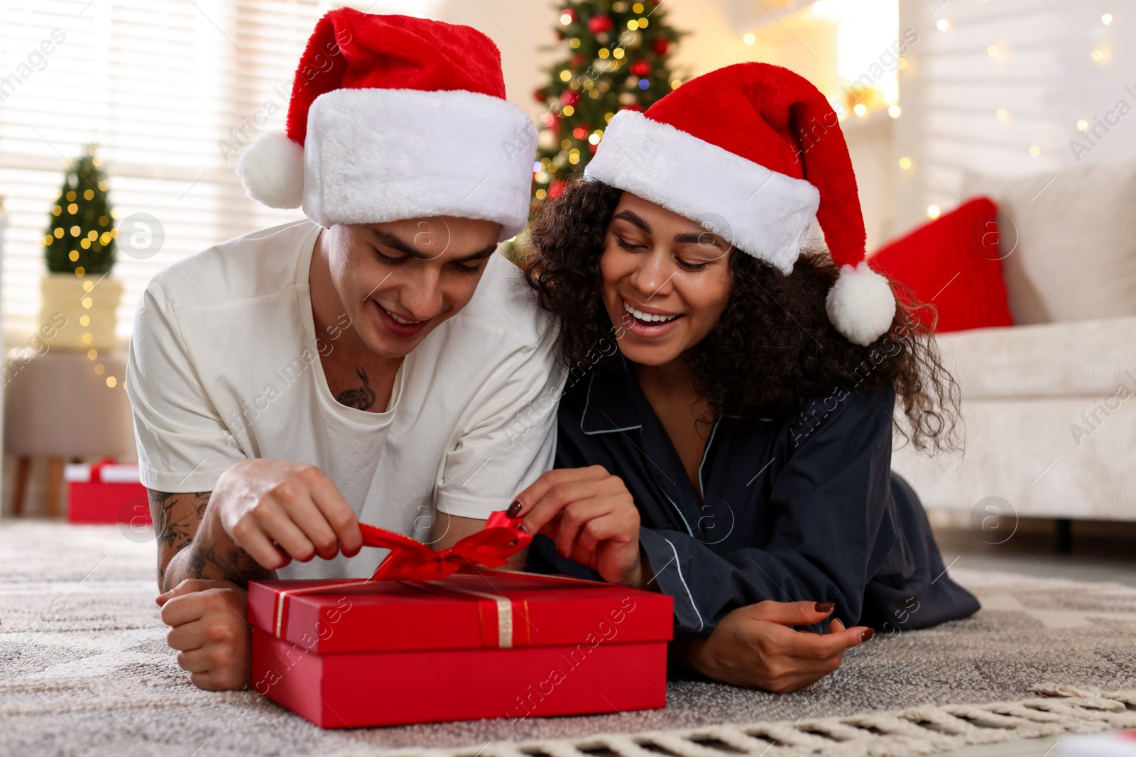 Photo of Happy couple with Christmas gift spending time together at home