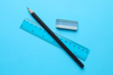 Photo of Eraser, pencil and ruler on light blue background, top view