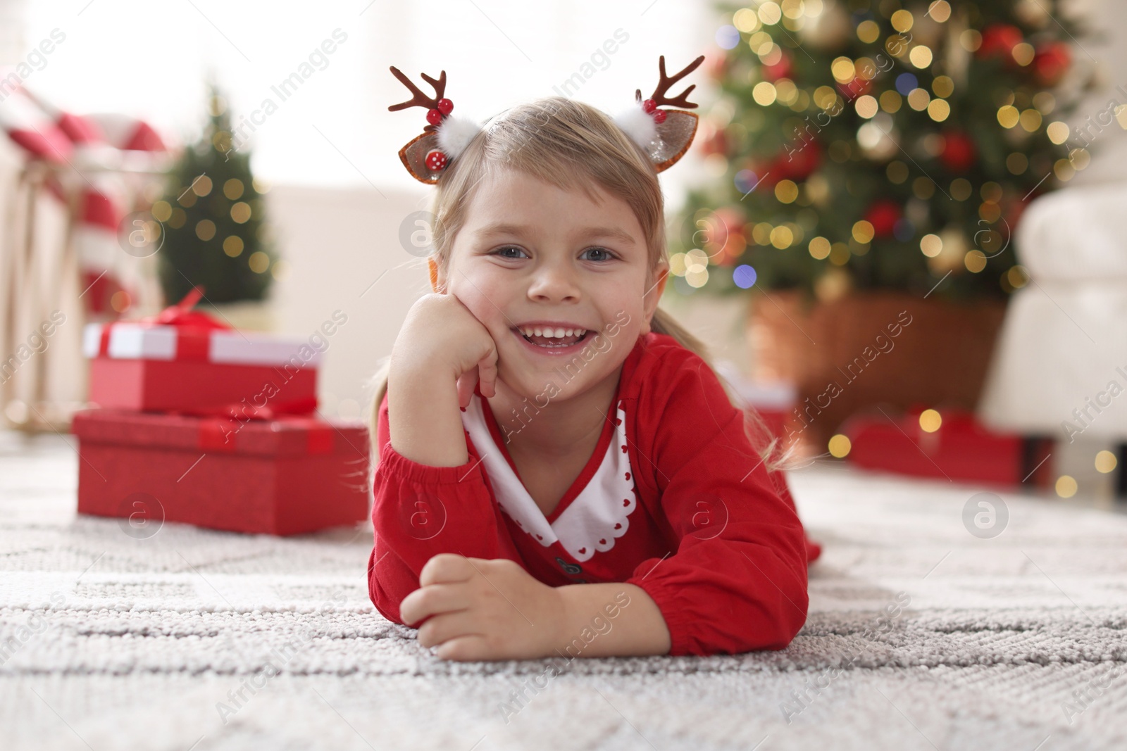 Photo of Little girl in Christmas costume lying on floor at home