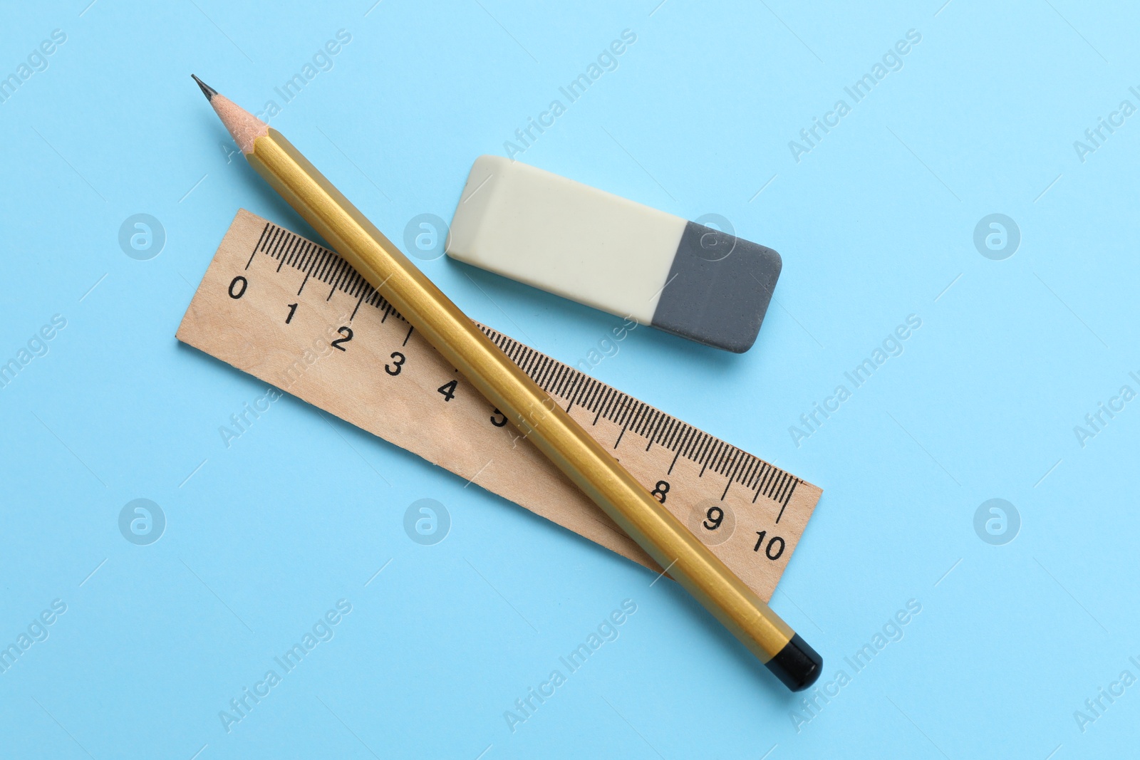 Photo of Eraser, pencil and ruler on light blue background, top view