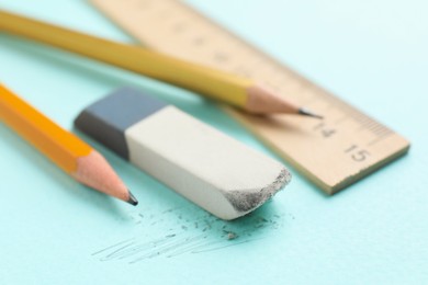 Photo of Eraser, pencils and ruler on light blue background, closeup