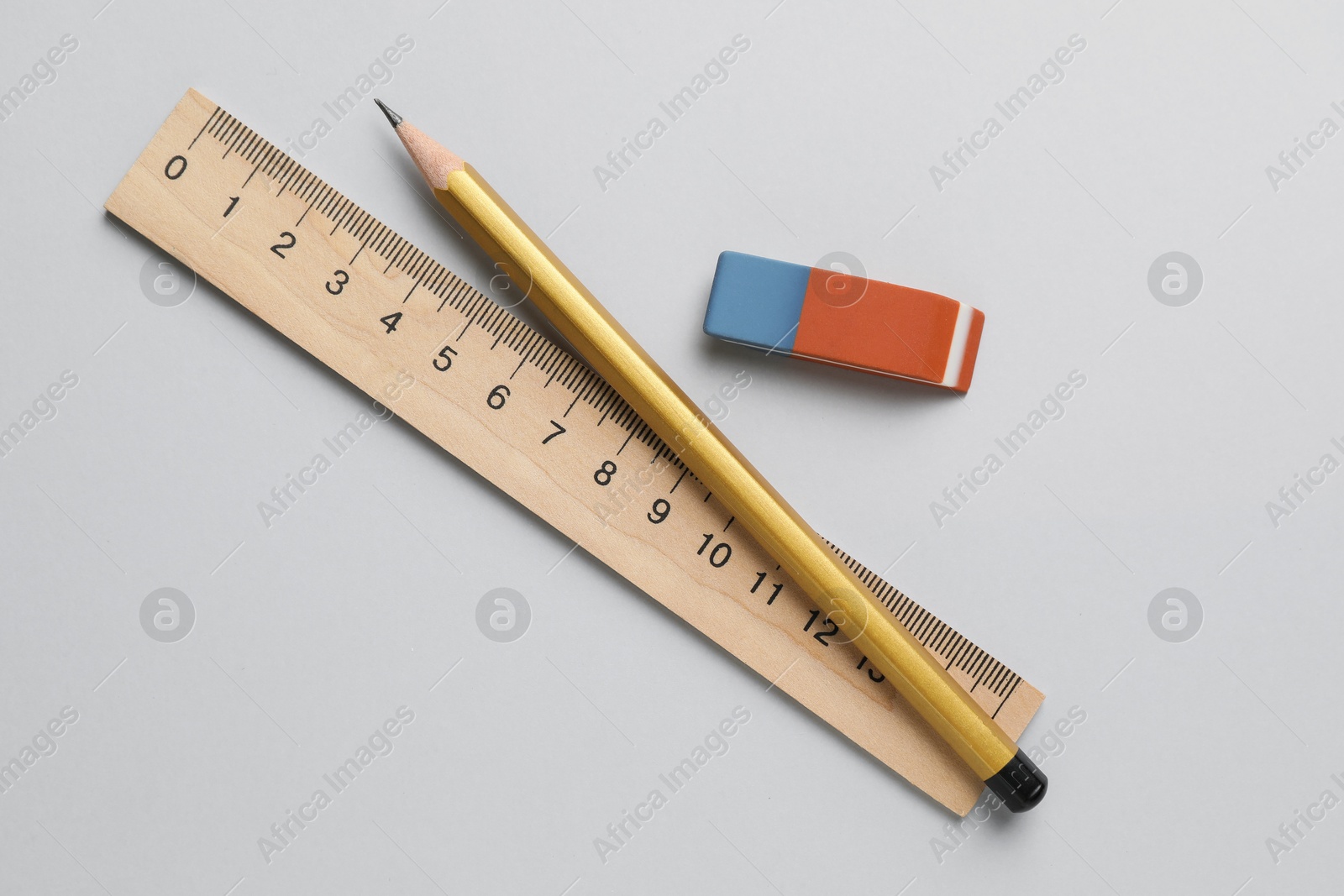 Photo of Eraser, pencil and ruler on light background, top view